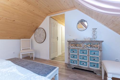 a bedroom with a bed and a dresser and a chair at Natura vendégház in Abaújvár