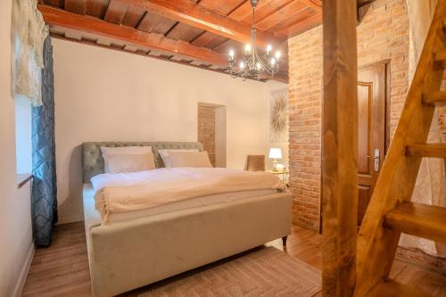 a bedroom with a bed and a brick wall at Natura vendégház in Abaújvár