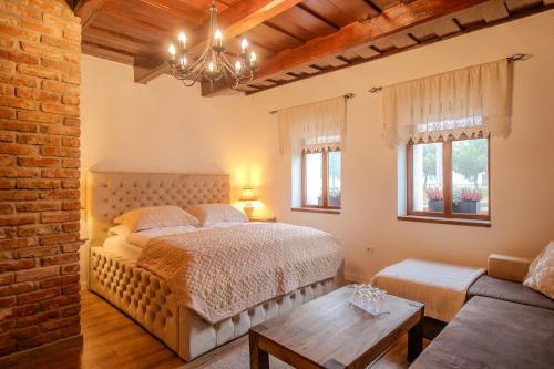 a bedroom with a large bed and a couch at Natura vendégház in Abaújvár