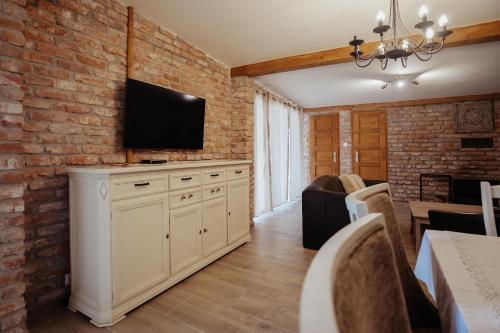 a living room with a tv on a brick wall at Natura vendégház in Abaújvár