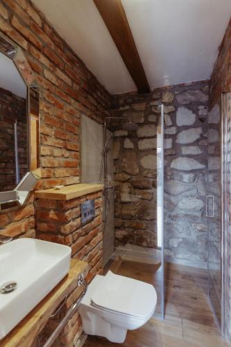 a stone bathroom with a toilet and a sink at Natura vendégház in Abaújvár