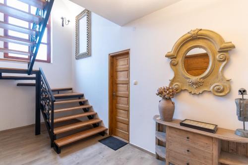 a room with a staircase and a mirror on the wall at Natura vendégház in Abaújvár