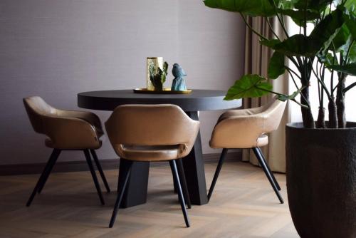 a black table with two chairs and a plant at Van der Valk Hotel Hengelo in Hengelo