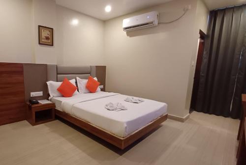 a bedroom with a bed with orange pillows at Hotel Elegant in Dimāpur