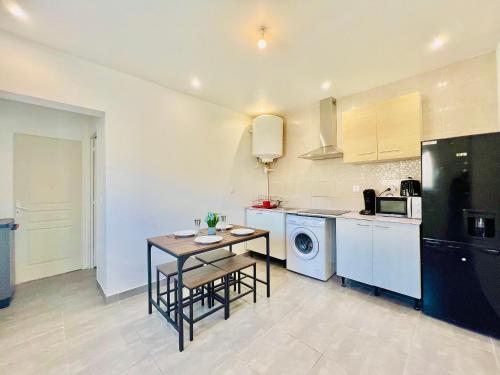a kitchen with a table and a table and a stove at Coeur de Fos-Centre Ville-CLIM-Plages-Parking-4 personnes in Fos-sur-Mer