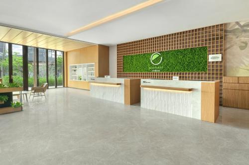 an office lobby with a reception counter and a brick wall at Element Yangjiang Hailing Island in Yangjiang