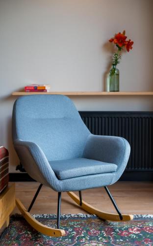 a blue chair sitting in a living room at 1740 Boutique Hotel Kazbegi in Stepantsminda