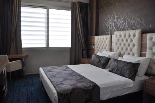 a hotel room with a bed with a window and a window at Orty Airport Hotel in Izmir
