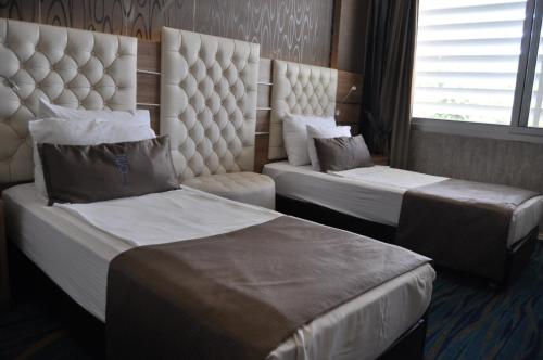 a hotel room with two beds and a window at Orty Airport Hotel in Izmir