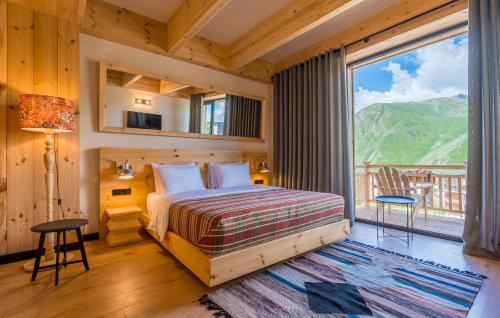 una camera da letto con un letto e una grande finestra di 1740 Boutique Hotel Kazbegi a Kazbegi