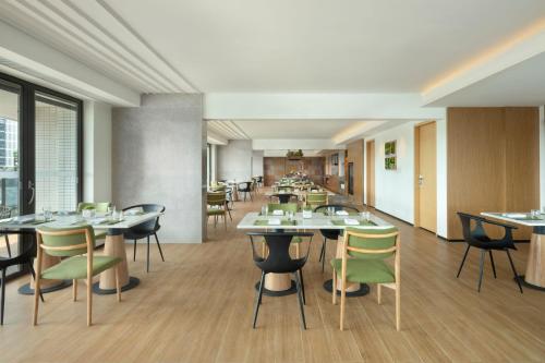 a restaurant with tables and chairs in a room at Element Yangjiang Hailing Island in Yangjiang