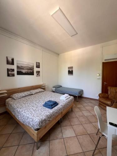 a bedroom with a bed and a couch and a table at Mini appartamento in centro storico in Castel San Pietro Terme