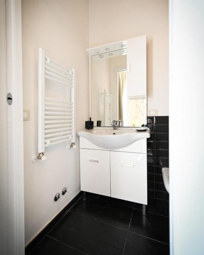 a white bathroom with a sink and a mirror at Agriturismo Colle Salomonio in Nepi