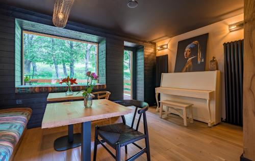 a living room with a table and a piano at 1740 Boutique Hotel Kazbegi in Stepantsminda