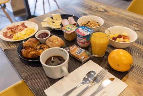 een ontbijtpakket met ontbijtproducten en drankjes op een tafel bij Hôtel Paris Madrid in Lesperon