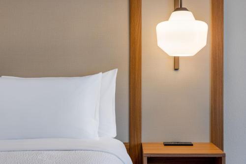 a bedroom with a bed with a white pillow and a lamp at Fairfield Inn & Suites by Marriott Fort Walton Beach Hurlburt Area in Fort Walton Beach