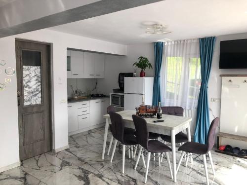 Una cocina con una mesa y sillas en una habitación. en Casa din gradina, en Poiana Mărului