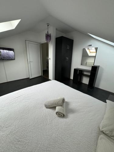 a bedroom with a white bed with a towel on it at Sarajevo Deluxe penthouse and pool in Sarajevo
