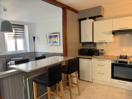 a kitchen with a counter and some chairs in it at La Maison de la Cour in Avon