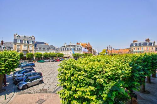 un groupe de voitures garées sur un parking dans l'établissement Le Morny Palace - 2P - Place Morny - DEAUVILLE, à Deauville