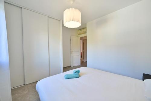 a bedroom with a white bed with a blue towel on it at Villa provençale Peical in Trans-en-Provence