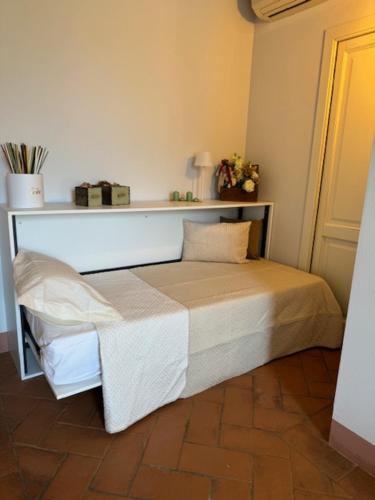 a bed in a room with a shelf on the wall at My Tuscany Relais in Altopascio