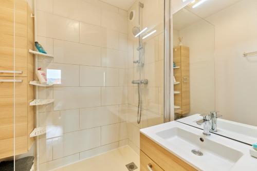 une salle de bain blanche avec une douche et un lavabo dans l'établissement Le Plein Soleil - Appt pour 6 proche de la plage, à Villers-sur-Mer