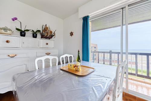 - une salle à manger avec une table et une bouteille de vin dans l'établissement Le Plein Soleil - Appt pour 6 proche de la plage, à Villers-sur-Mer