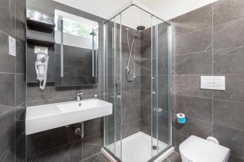 a bathroom with a sink and a glass shower at B&B Hotel Pomezia Roma in Pomezia