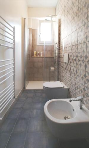 a bathroom with a toilet and a sink and a shower at Appartamento AURORA in Follonica