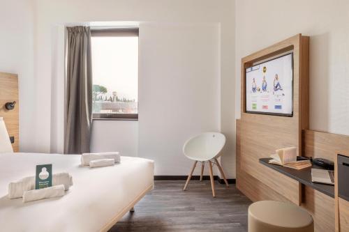a hotel room with a bed and a tv at B&B Hotel Pomezia Roma in Pomezia
