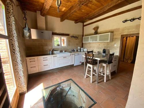 une grande cuisine avec une table et des chaises. dans l'établissement O Gîte Clément, à Molières