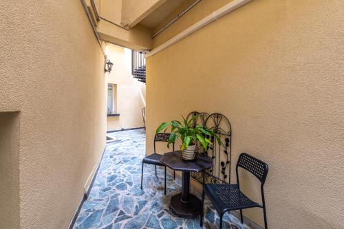 une petite table et des chaises dans un couloir avec une plante dans l'établissement Relais Bergson, à Paris
