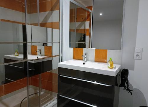 a bathroom with two sinks and a mirror at L'étoile de Zakiel in Cambayrac