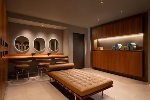 a room with a bed and a bar with stools at Sheraton Lake Como Hotel in Como