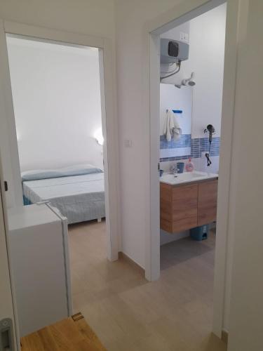a bathroom with a sink and a bed and a mirror at Beach Rooms 1 Self Check-in in Alghero