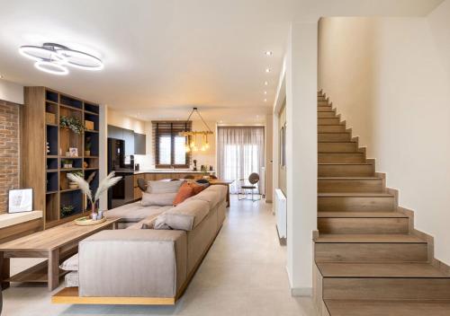 un soggiorno con un divano e una scala di Olive Boutique Villas a Larisa
