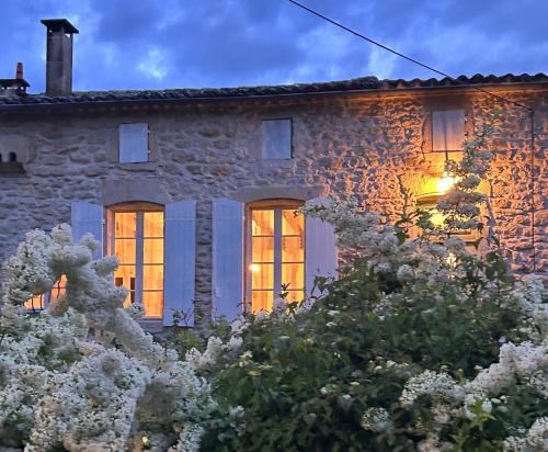 una casa di pietra con le luci accese di Le Refuge d'Alienor at Domaine Le Touran near Saint Emilion a Pellegrue