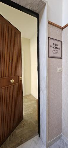 a room with a door and a sign on the wall at B&B Via Roma in Gioia del Colle