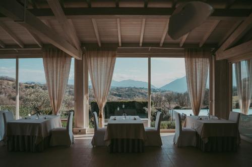 a dining room with tables and chairs and windows at RELAIS COLLE BUONO in Alvito