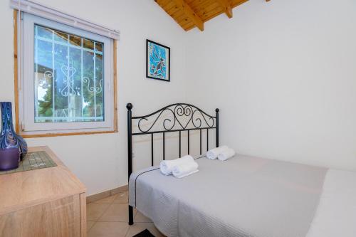 a bedroom with a bed with two towels on it at Evaggelia's Summer Resort in Dhíkella