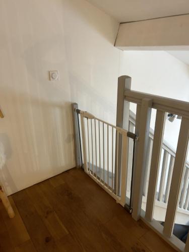 a staircase in a room with white walls and wooden floors at LE PAOLO Appartement Deluxe in Narbonne