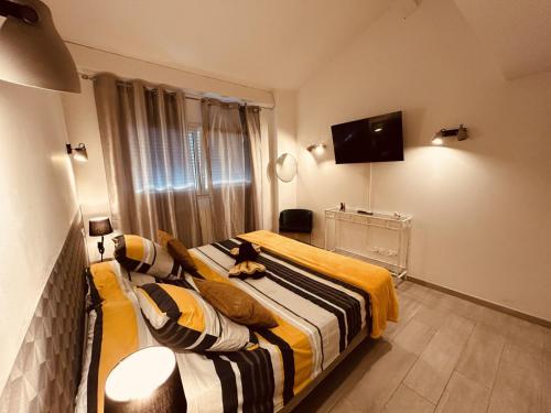 a bedroom with two beds and a tv on the wall at LE PAOLO Appartement Deluxe in Narbonne