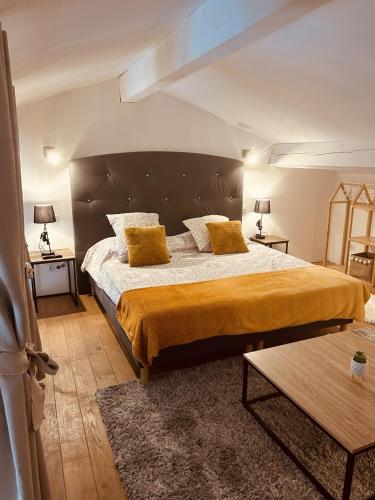 a bedroom with a large bed with yellow pillows at LE PAOLO Appartement Deluxe in Narbonne