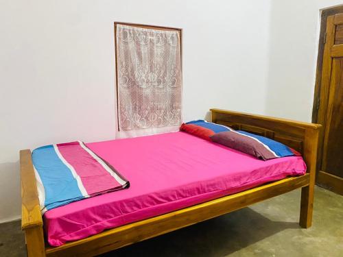 ein Bett in einem Zimmer mit Fenster in der Unterkunft Senthu guest house in Point Pedro
