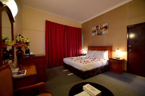 a hotel room with a bed and a red curtain at Nejoum Al Emarat in Sharjah