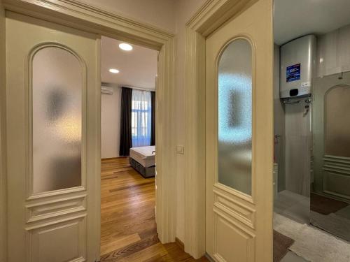a hallway with two glass doors and a bedroom at City center appartment in Pula