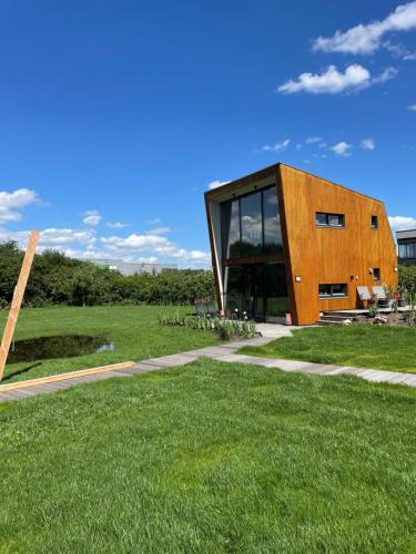 a building with glass doors on a grass field at Casitas Wijchen in Wijchen