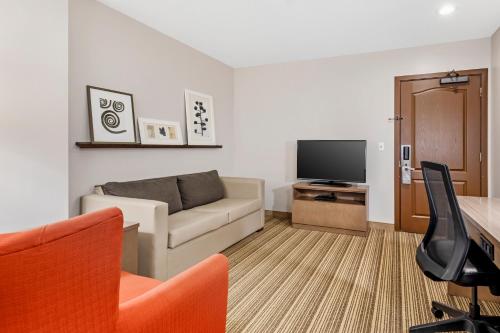 a living room with a couch and a television at Country Inn & Suites by Radisson, Annapolis, MD in Annapolis