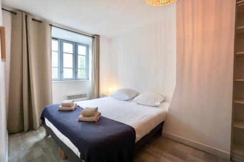 une chambre avec un lit avec des serviettes dessus dans l'établissement La petite maison de pêcheur, à Concarneau